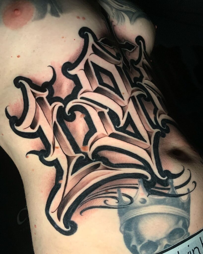 High-contrast blackwork Gothic script ribcage tattoo with ornate 3D lettering and shaded crowned skull.