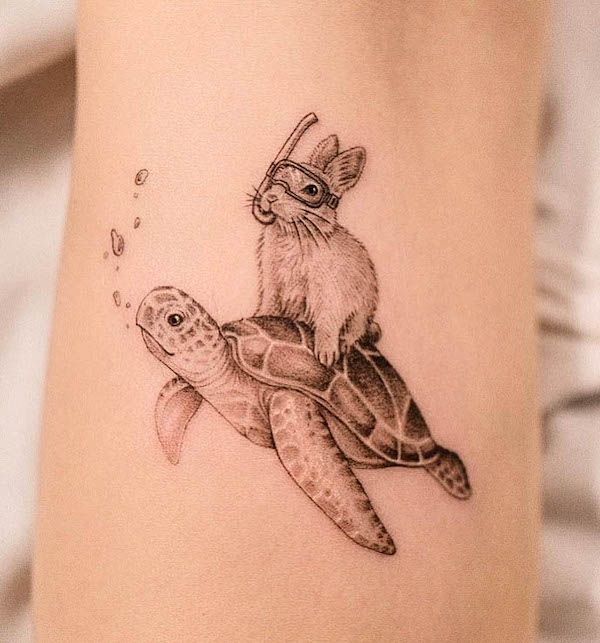 Black ink tattoo of a rabbit wearing snorkeling goggles riding a swimming sea turtle, whimsical animal design on skin