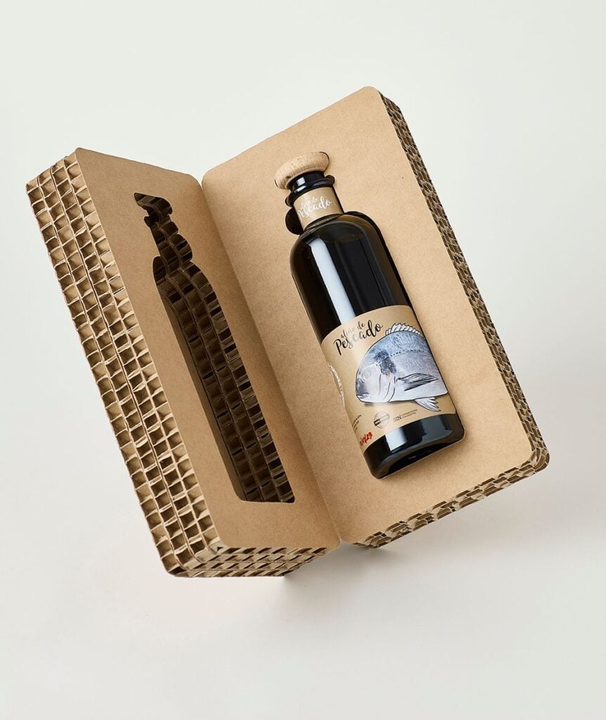Eco-friendly corrugated cardboard gift box with dark glass bottle featuring fish label — sustainable packaging for specialty oils and condiments.