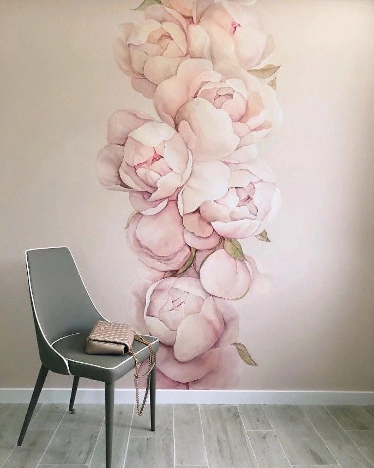 Blush pink peony wall mural with modern gray chair and quilted purse in a minimalist room with light wood tile floor