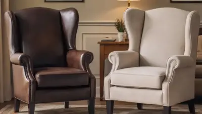 Pair of brown leather and beige fabric wingback armchairs in a styled cozy living room with wooden side table