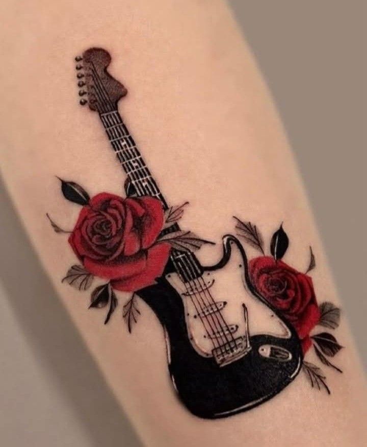 Black electric guitar tattoo with red roses and leaves on inner forearm — music-inspired floral ink