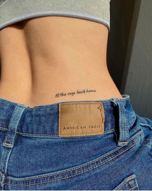 Close-up of lower back with small script tattoo All the rage back home paired with American Eagle denim waistband