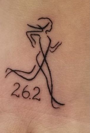 Minimalist line-drawing tattoo of a running woman with 26.2 text, a marathon finisher symbol on skin