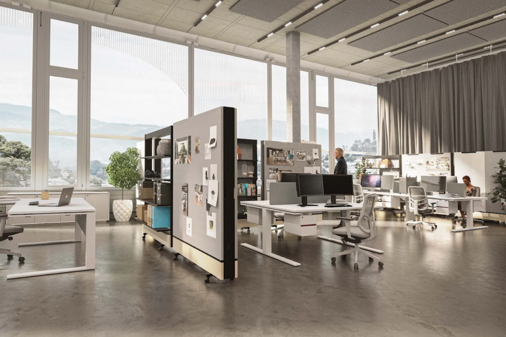 Bright modern open-plan office with adjustable desks, dual monitors, movable partitions and floor-to-ceiling windows