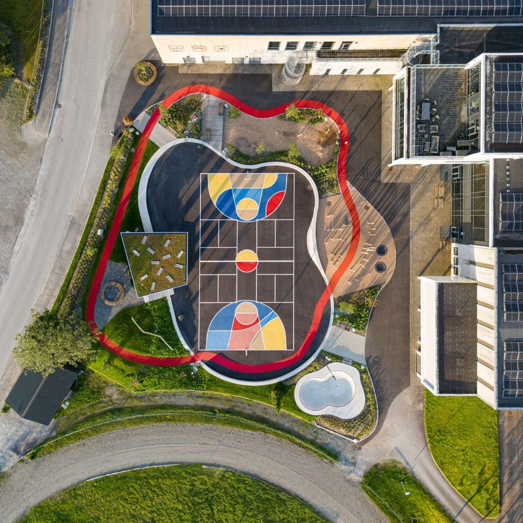 19c4c4951840627a0a1d32dd8a483181 Aerial view of colorful geometric basketball court surrounded by red running track and modern buildings with solar panels | Sky Rye Design Aerial view of colorful geometric basketball court surrounded by red running track and modern buildings with solar panels