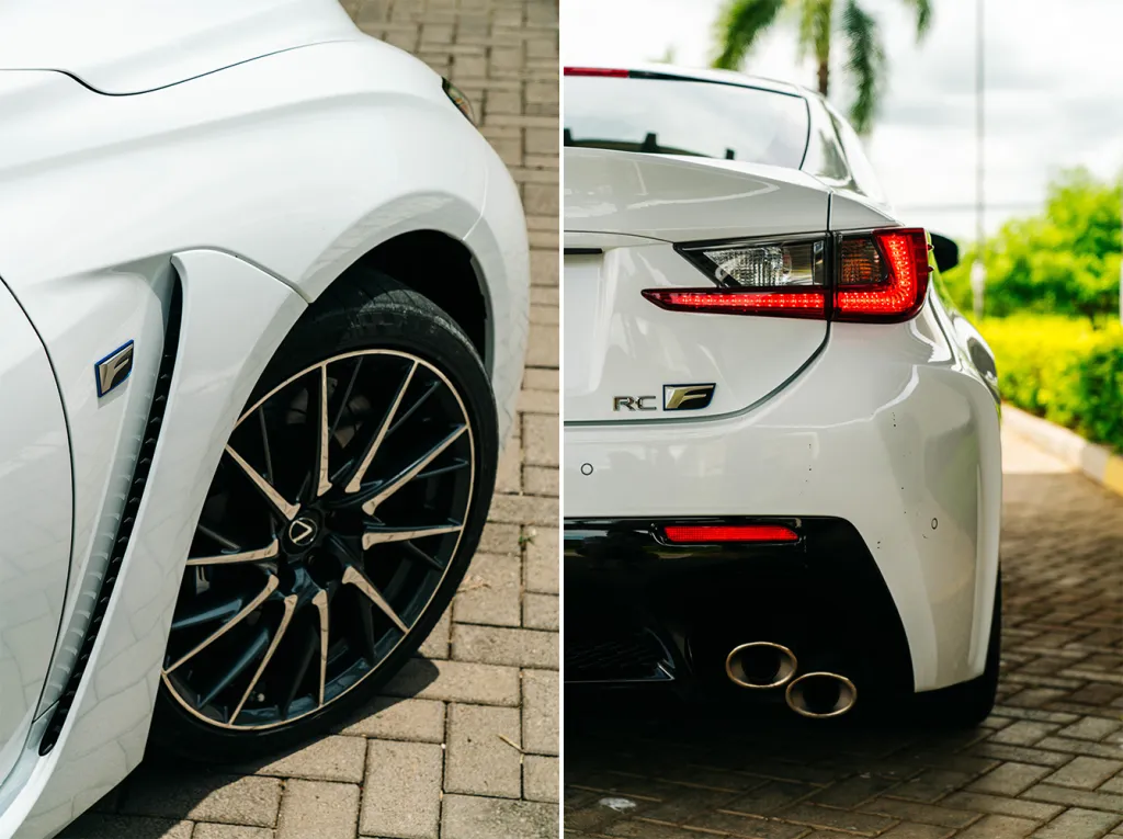 White Lexus RC F sports car split close-up: front alloy wheel and rear taillight with dual exhaust on paved driveway