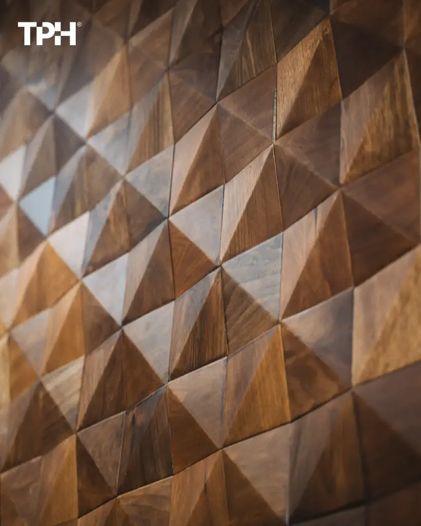 Close-up of 3D geometric wooden wall panels with triangular pyramid tiles in warm walnut finish