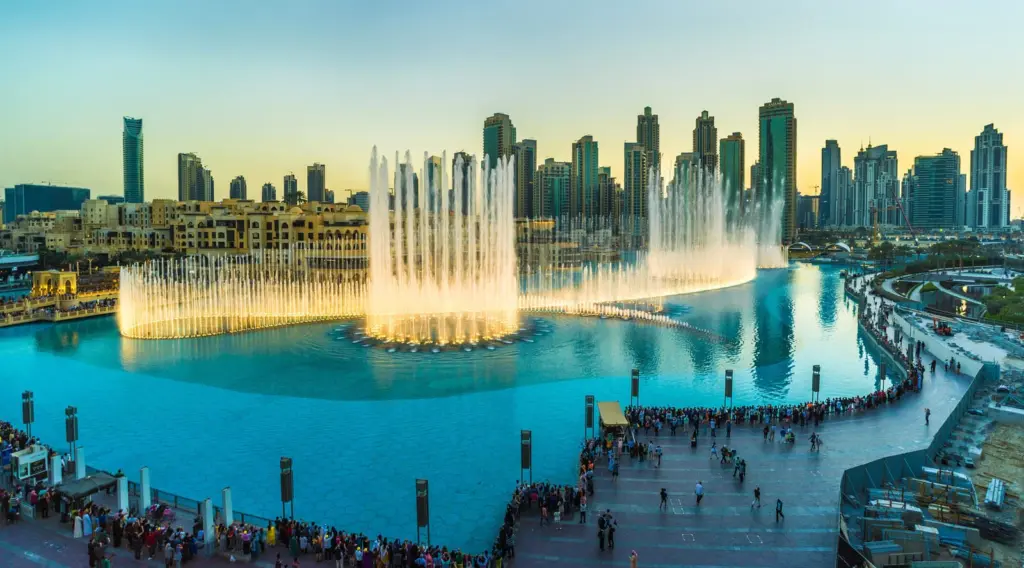 3 Dubai Fountain show at dusk on Burj Khalifa Lake with illuminated jets, Downtown Dubai skyline and crowds watching | Sky Rye Design Dubai Fountain show at dusk on Burj Khalifa Lake with illuminated jets, Downtown Dubai skyline and crowds watching