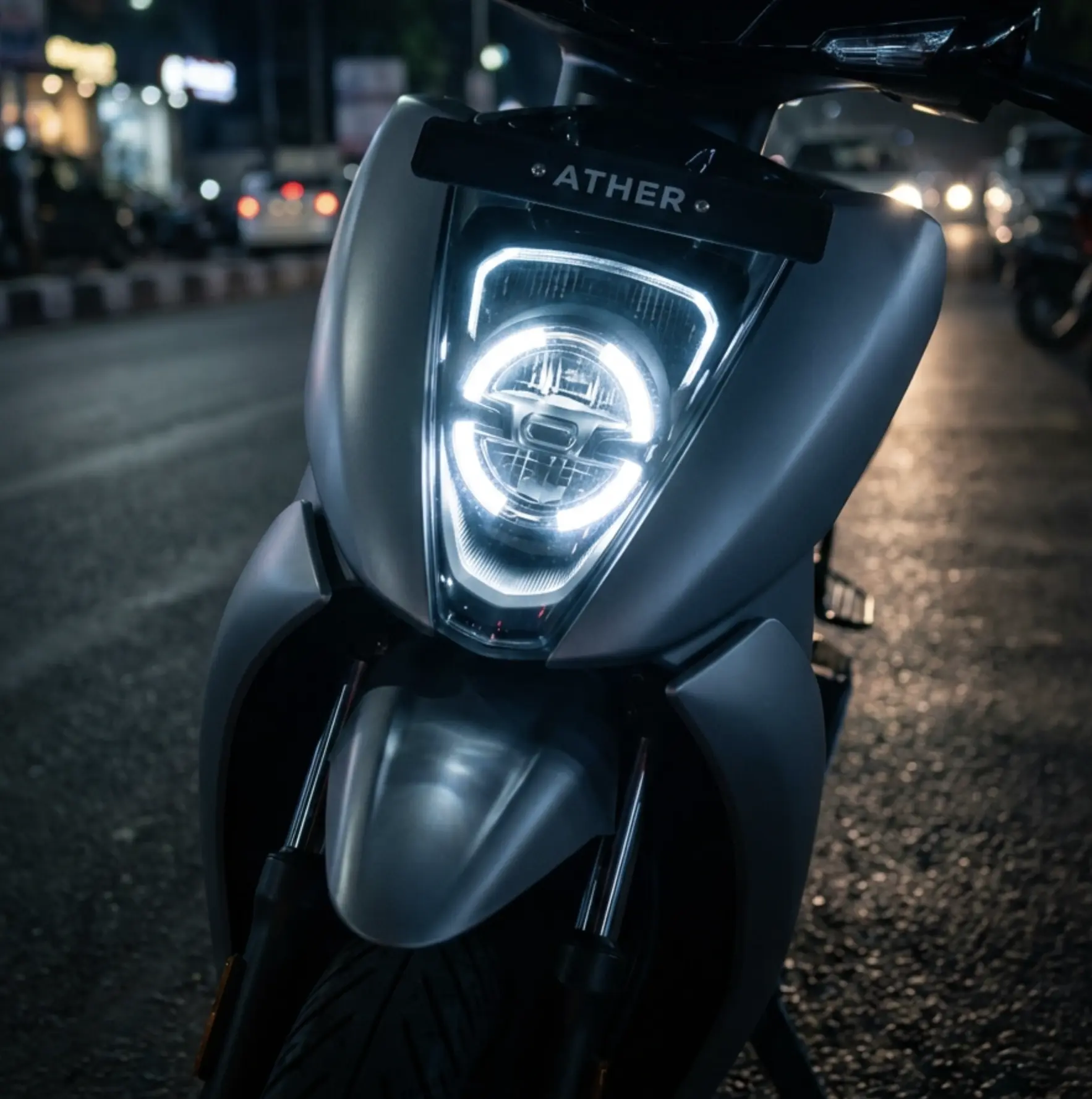 Ather electric scooter LED headlight close-up on urban street at night