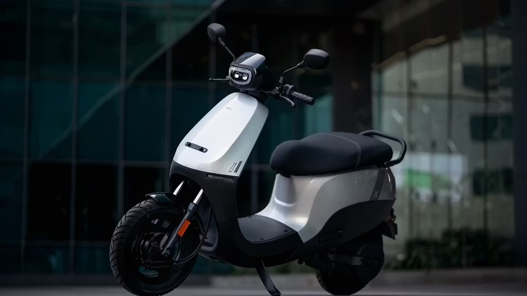 White electric scooter parked in front of glass building, modern urban commuter e-scooter