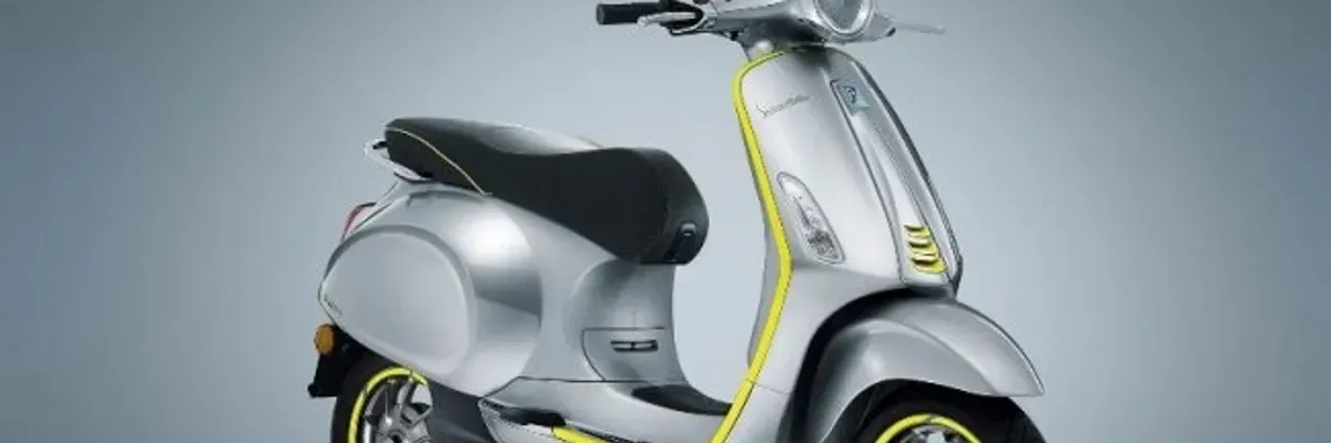 Silver retro commuter scooter with neon yellow trim, black seat and alloy wheels on a gray backdrop