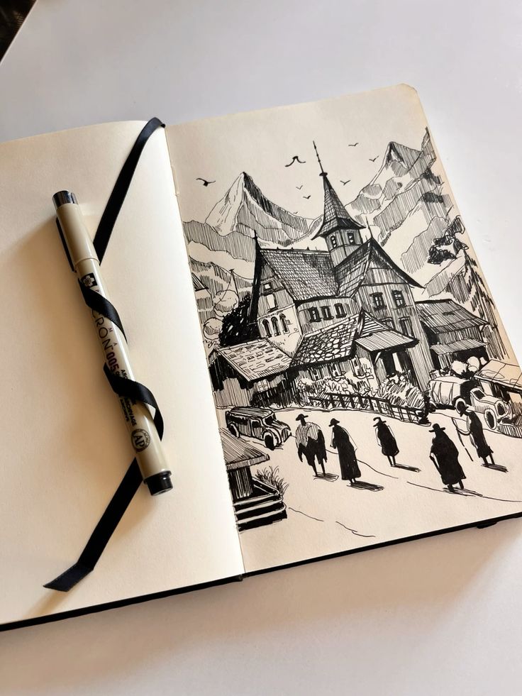 Black ink pen sketch of an Alpine village church and mountains in an open sketchbook, pen beside drawing