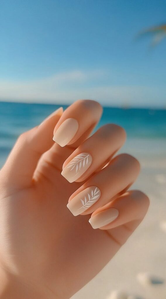 Sunlit hand with nude square manicure and white leaf nail art, turquoise ocean beach background