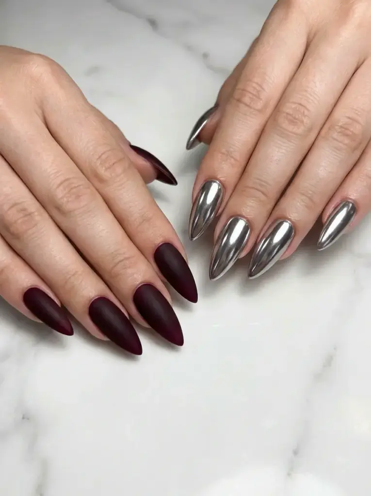 Long stiletto nails - matte burgundy on one hand and chrome silver mirror on the other, on white marble background