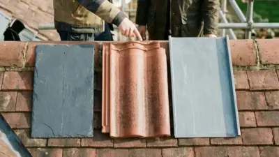 Slate, clay barrel, and metal roofing samples displayed on tiled roof as workers compare options