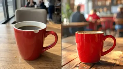 Red ceramic coffee mug on wooden table in cozy cafe, filled with black coffee, blurred patrons in background
