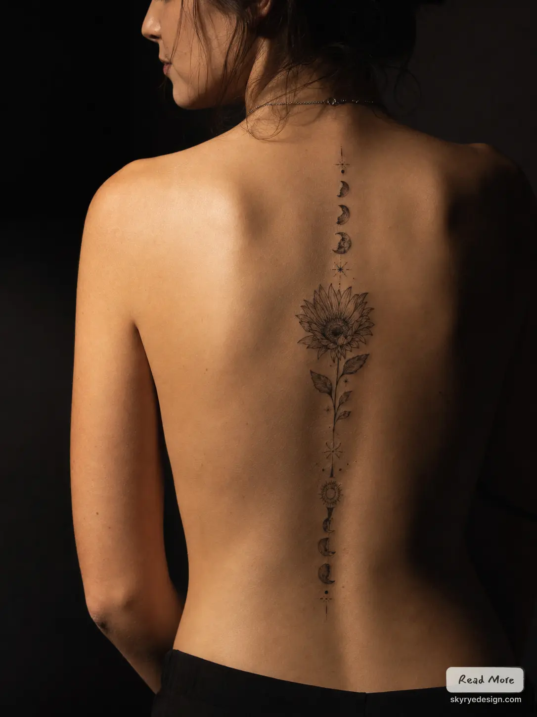 Vertical fine-line sunflower and moon phases spine tattoo on woman's bare back, minimalist botanical celestial design