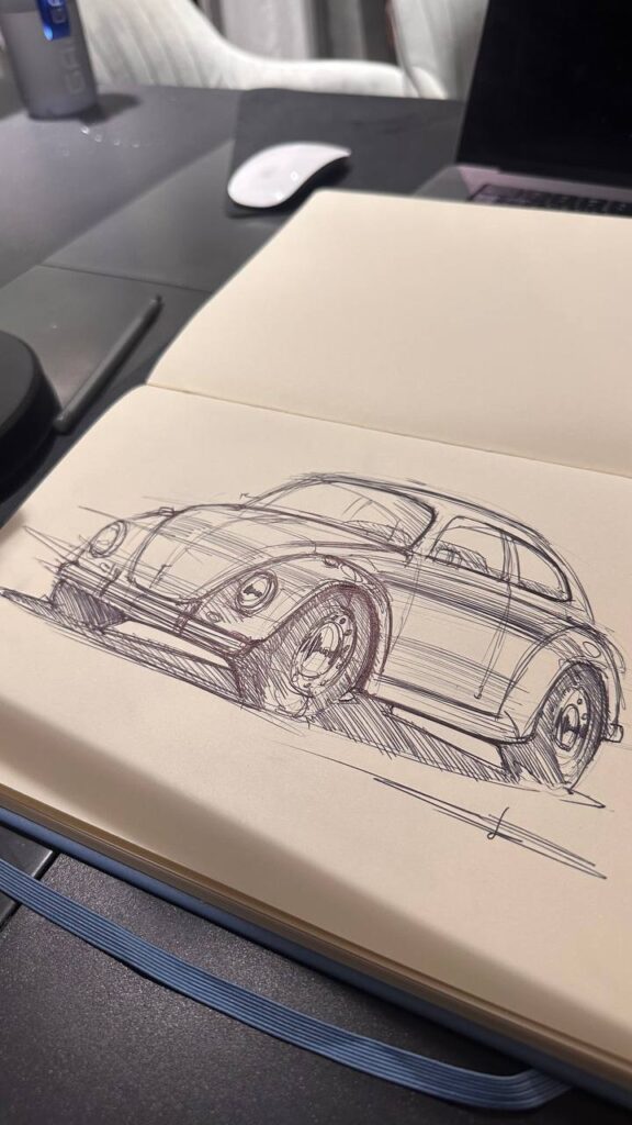 photo_2026-06-02_21-49-02 Hand-drawn pen sketch of retro compact car in open sketchbook on desk, automotive design concept with laptop and mouse nearby | Sky Rye Design Hand-drawn pen sketch of retro compact car in open sketchbook on desk, automotive design concept with laptop and mouse nearby