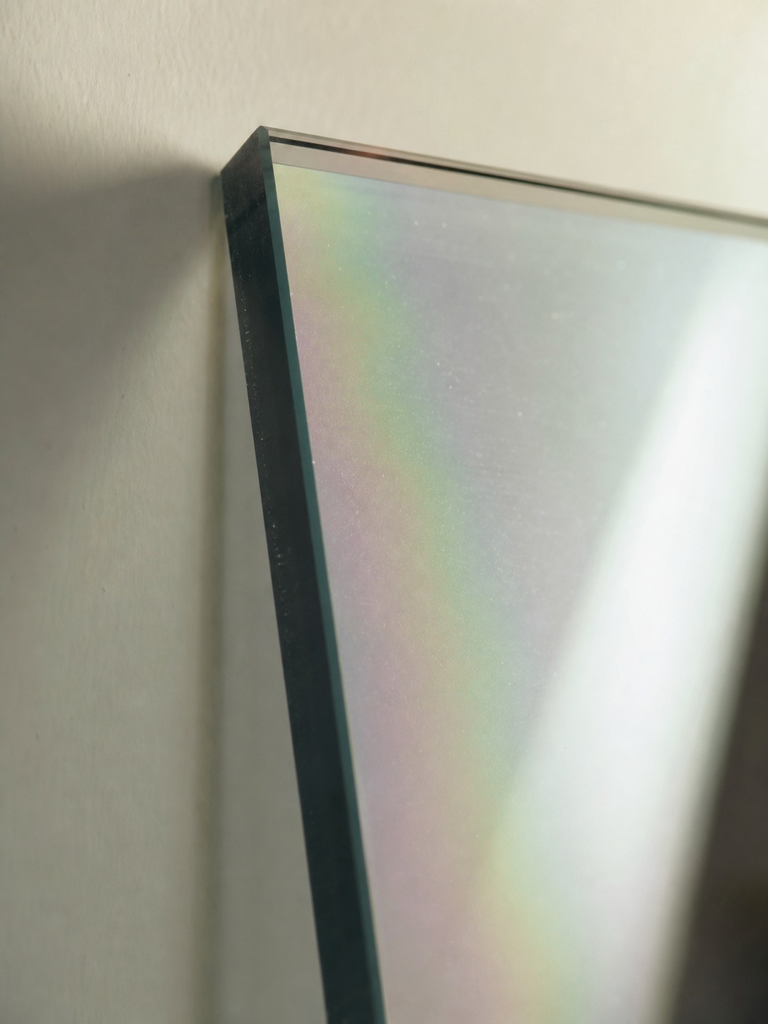 Close-up of Low-E architectural glass catching angled light with a subtle iridescent coating effect.