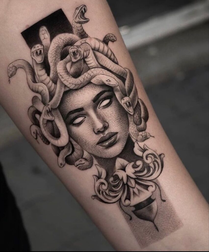 Tattoo of a Medusa-inspired woman's head with writhing snakes for hair on a forearm.