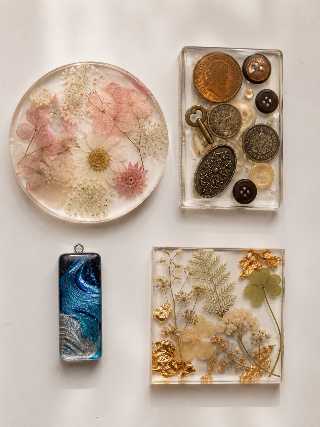Finished resin pieces with embedded flowers, coins, buttons, mica swirls, botanicals and gold leaf.