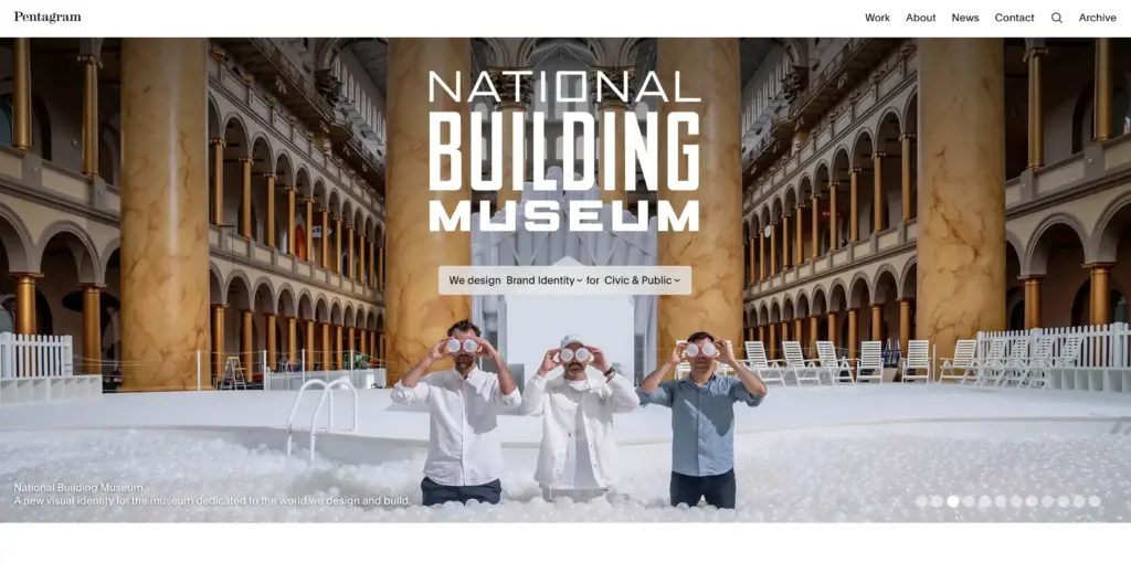 National Building Museum interior: grand arched hall with marble columns, exhibit logo and three people in a white ball pit.