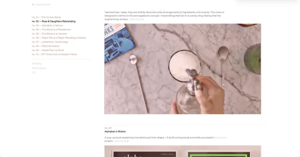 Overhead shot of marble countertop with bowl of sugar, two long spoons, cookbook and hands holding a syrup dispenser
