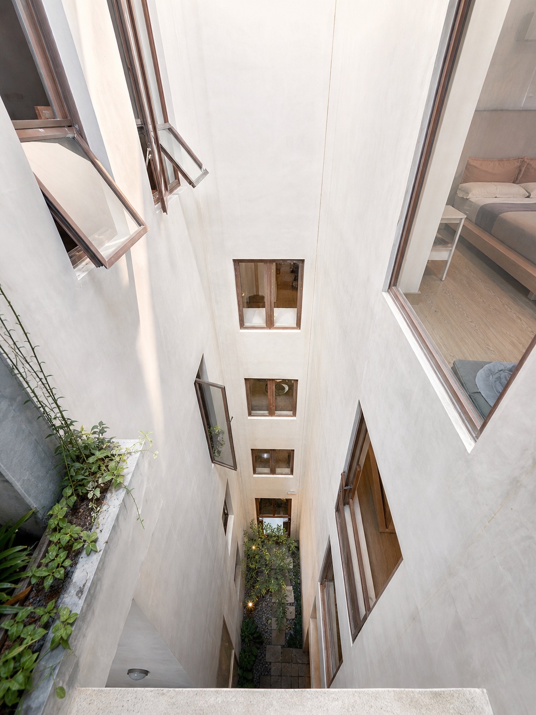 Architectural cutaway of a central light well A dollhouse-style cutaway shows daylight traveling through a vertical light well in a multi-story urban home. | Sky Rye Design A dollhouse-style cutaway shows daylight traveling through a vertical light well in a multi-story urban home.