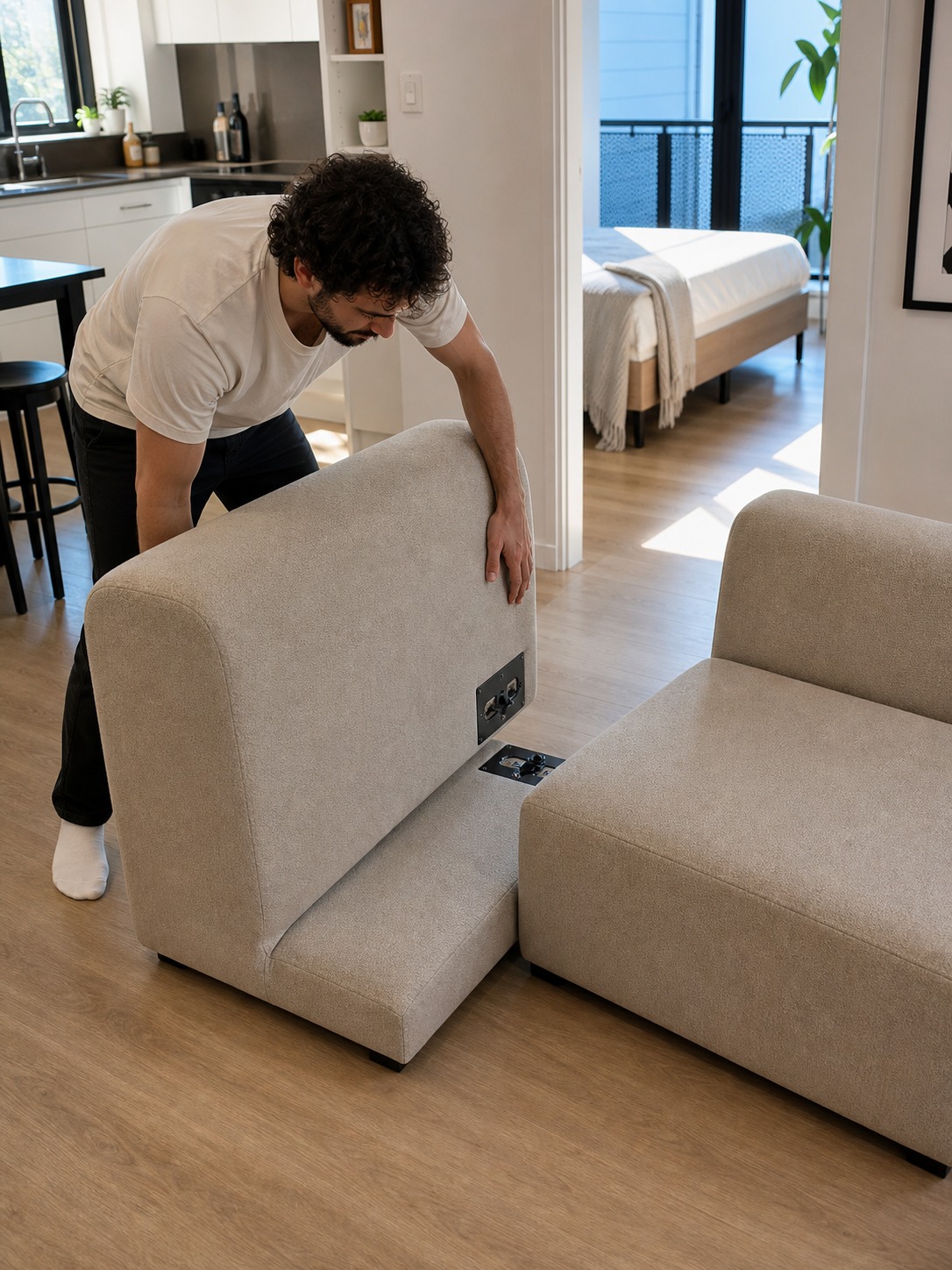 Person assembling a compact modular sofa in a modern apartment without tools.