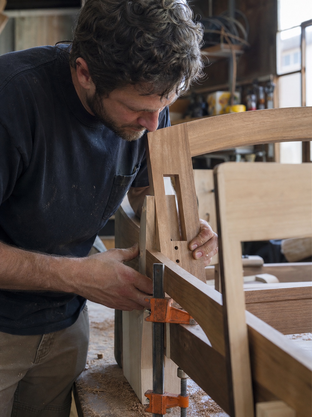 Craftsman assembling a solid hardwood sofa frame in a furniture workshop