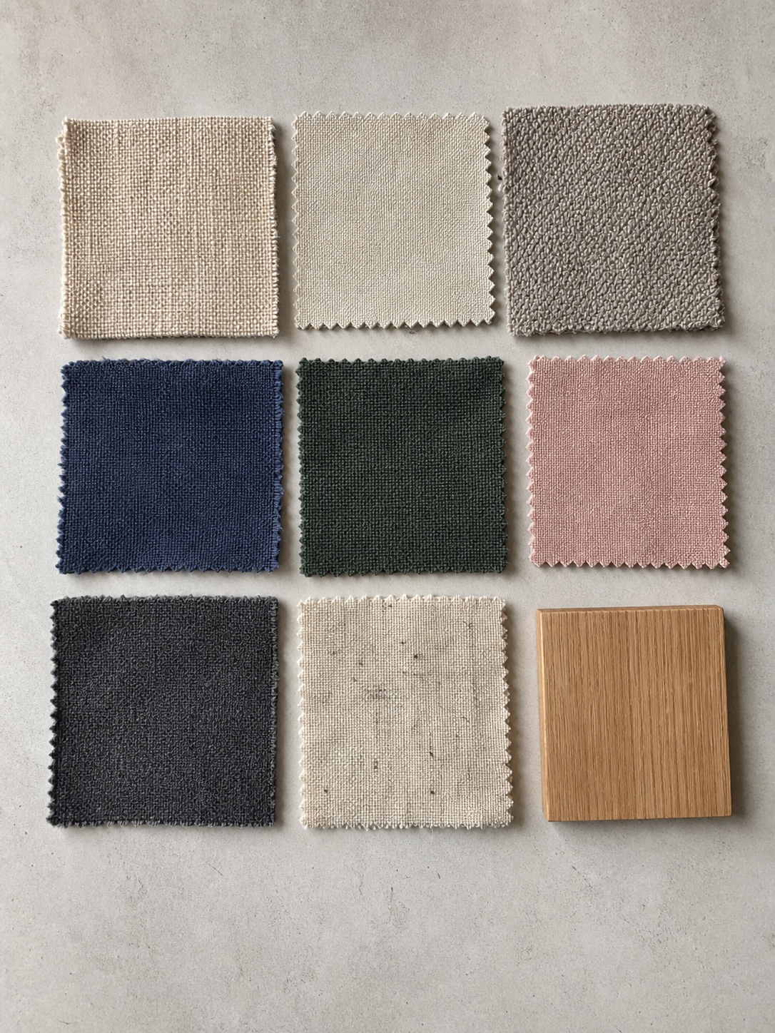 Grid of upholstery fabric swatches in warm neutrals, navy, green, blush, charcoal, and linen tones.