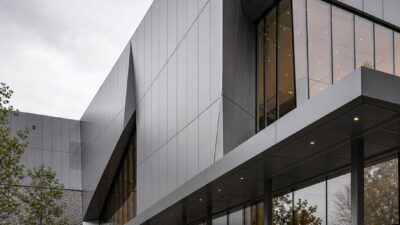 Contemporary building facade with fluoropolymer-coated metal panels and coated steel canopy details.