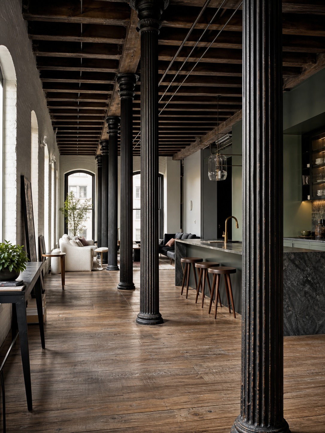 Historic Soho cast-iron loft interior with original columns and a custom kitchen beyond.