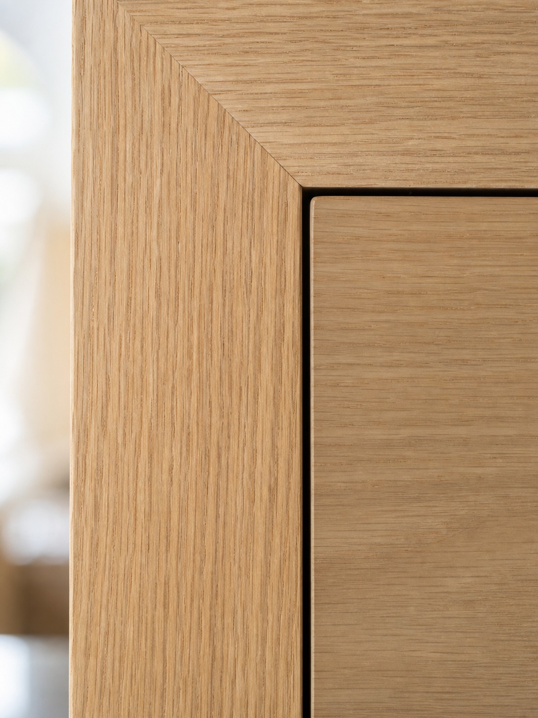 Macro detail of an in-frame oak cabinet door with a precise two millimeter reveal.