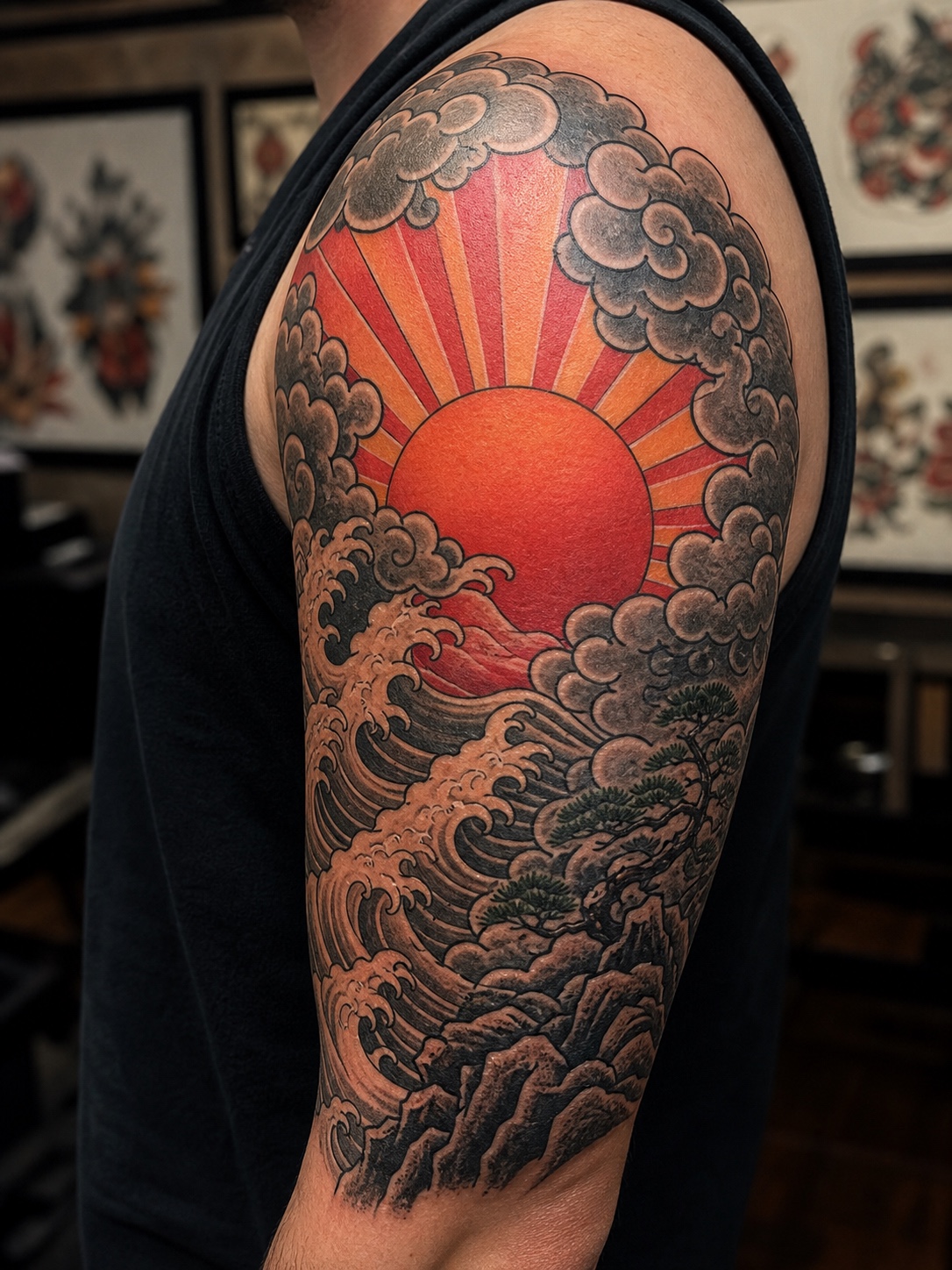 Japanese irezumi-inspired sunrise tattoo with clouds on an upper arm.
