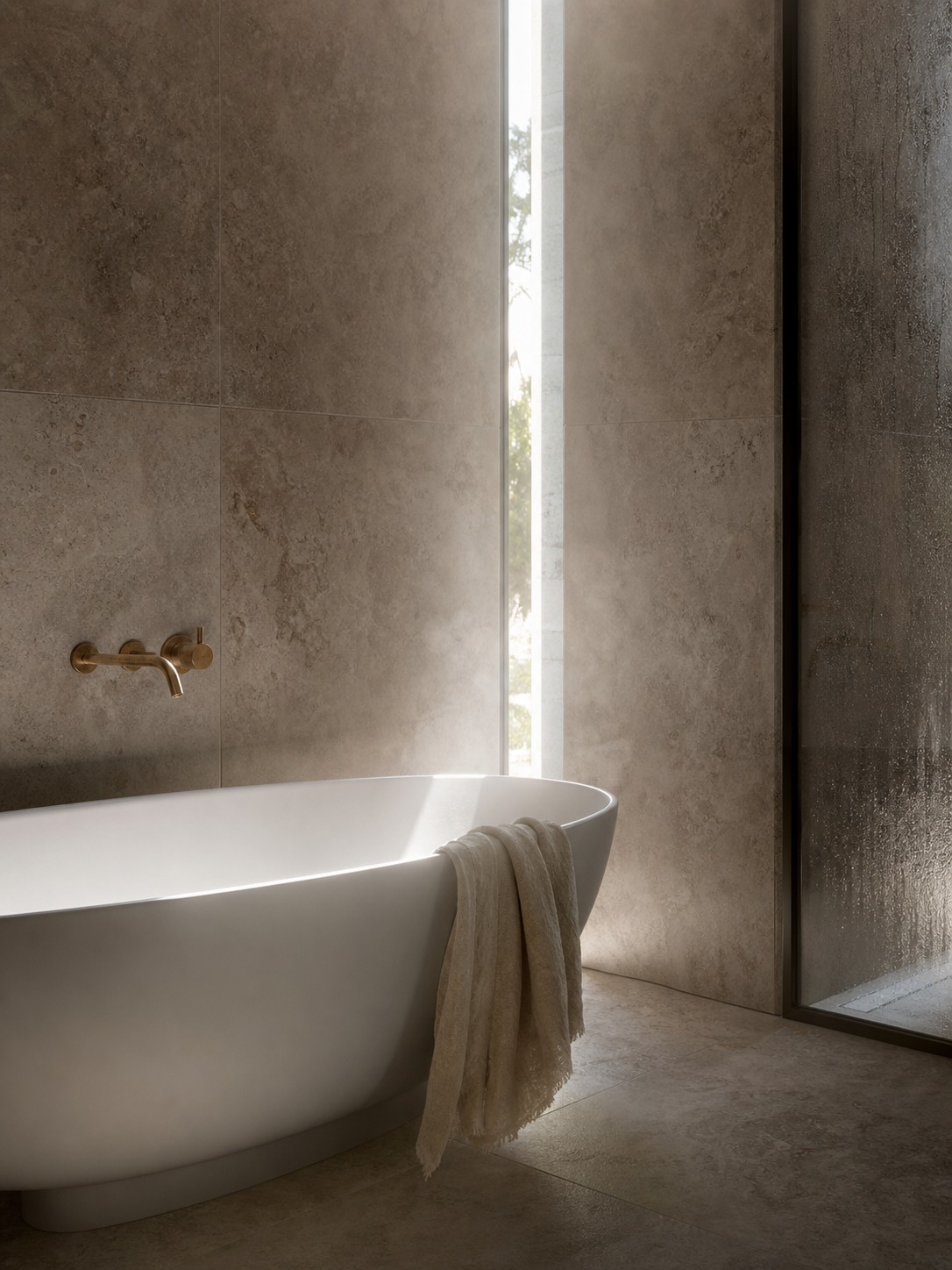 Luxury bathroom render with travertine tile, matte white bathtub, aged brass mixer, and a strip of daylight.