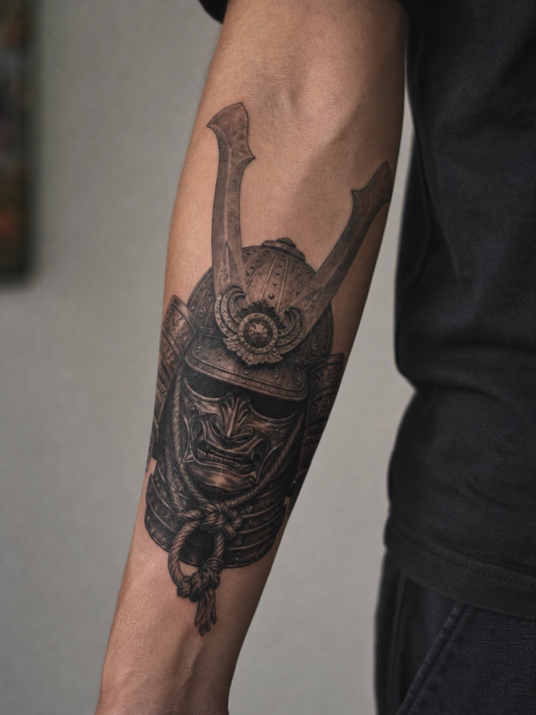Black and gray samurai helmet forearm tattoo Black and gray samurai helmet tattoo on a forearm with detailed armor shading. | Sky Rye Design Black and gray samurai helmet tattoo on a forearm with detailed armor shading.