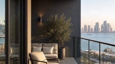 Shaded Abu Dhabi residential balcony with lounge furniture and city water view