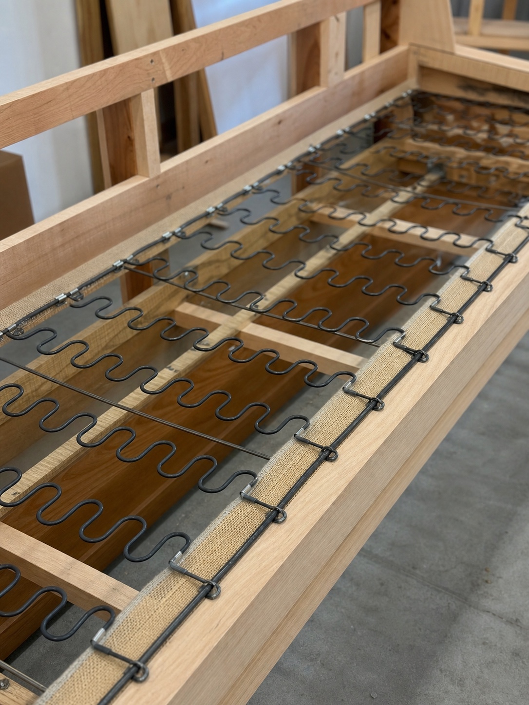 S-shaped steel springs installed across an unfinished sofa base
