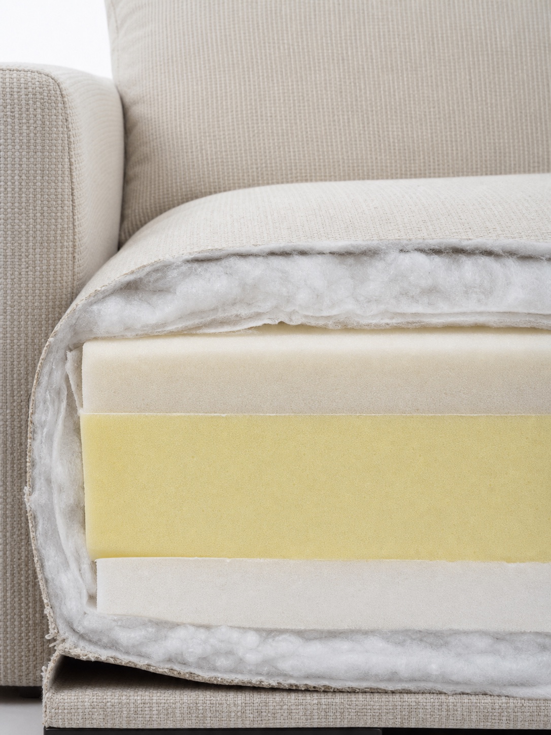 Clean cutaway of a sofa cushion showing layered high-density foam and wrapped fiber.