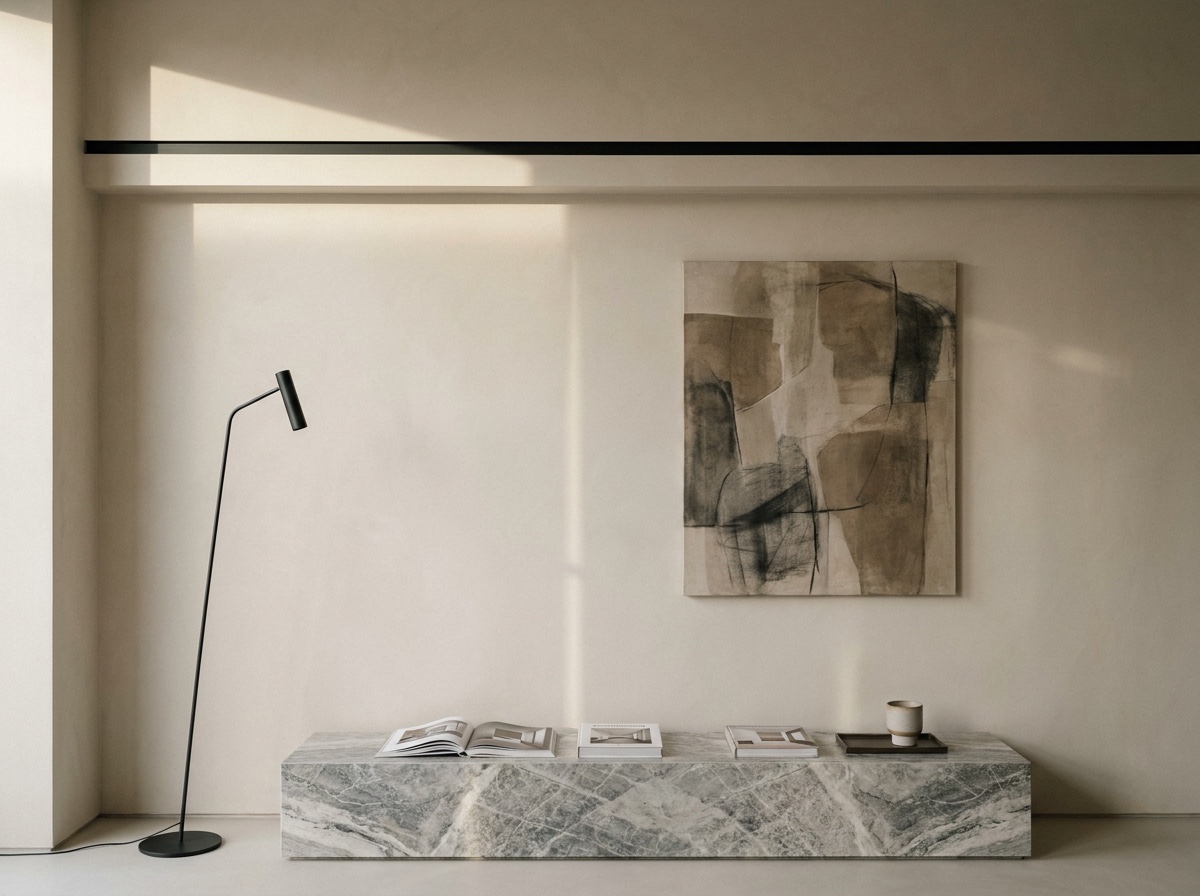 A tall modern room with a floor lamp, artwork, low bench, and a subtle horizontal trim band that organizes the wall height.