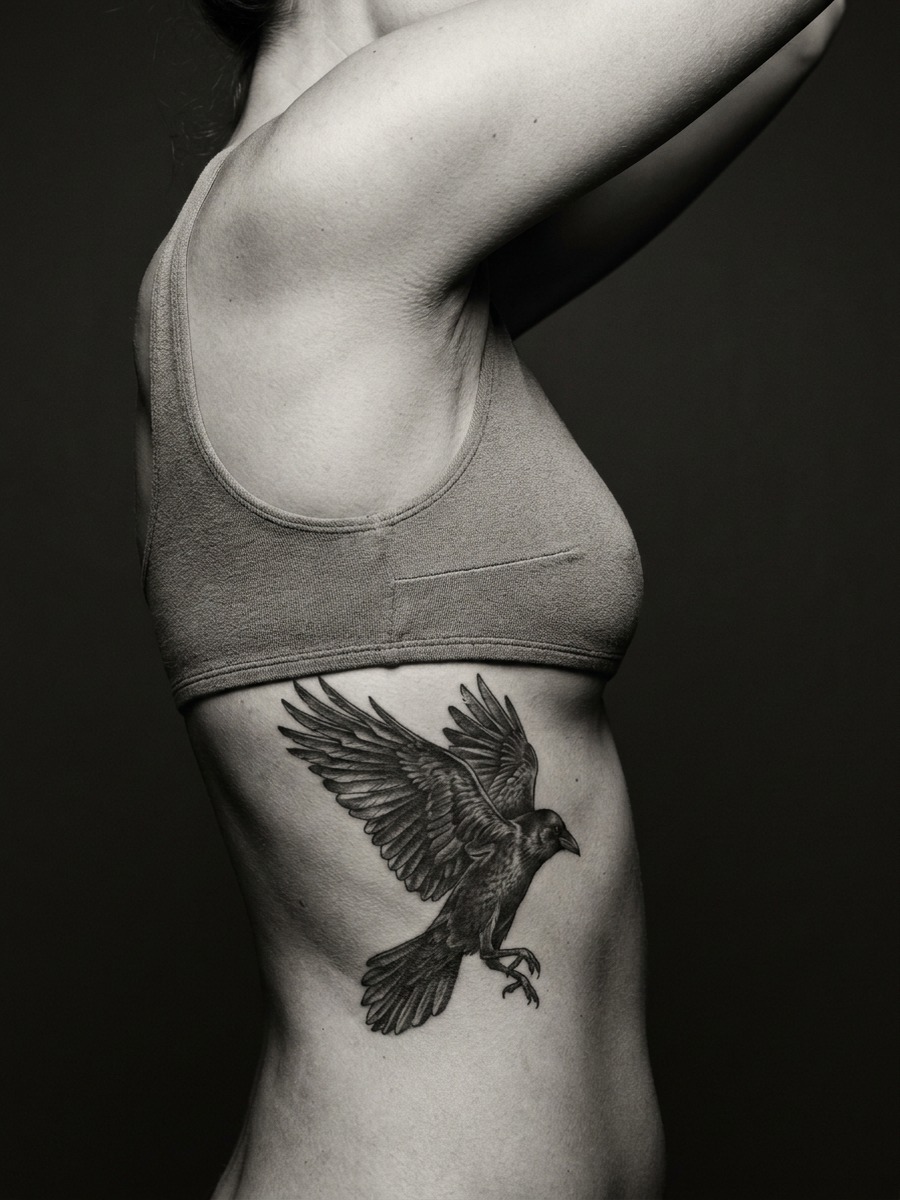 Large bird mid-takeoff on a woman's side torso and ribcage.