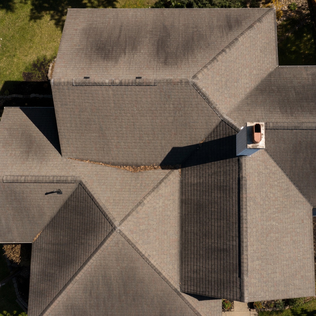 Top-down aerial view of a residential roof with valleys, ridges, and a chimney