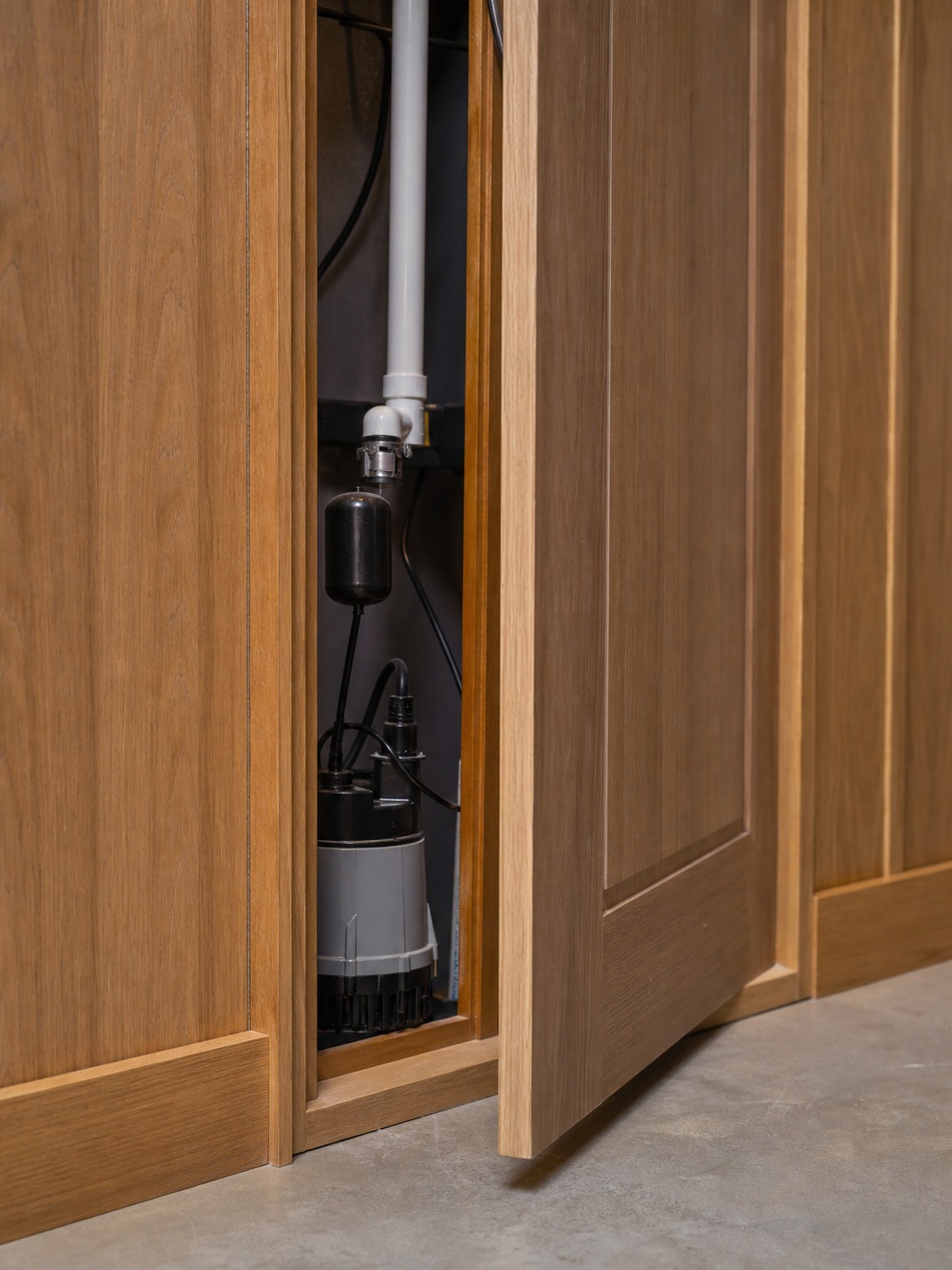 Hidden Closet Door Slim basement utility closet door built into millwork with sump pump access inside. | Sky Rye Design Slim basement utility closet door built into millwork with sump pump access inside.