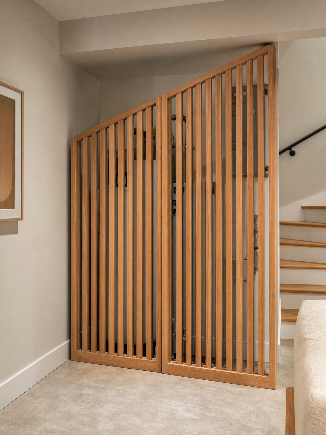 Slatted Screen Over Panel Slatted wood screen concealing utility equipment in a finished basement corner. | Sky Rye Design Slatted wood screen concealing utility equipment in a finished basement corner.