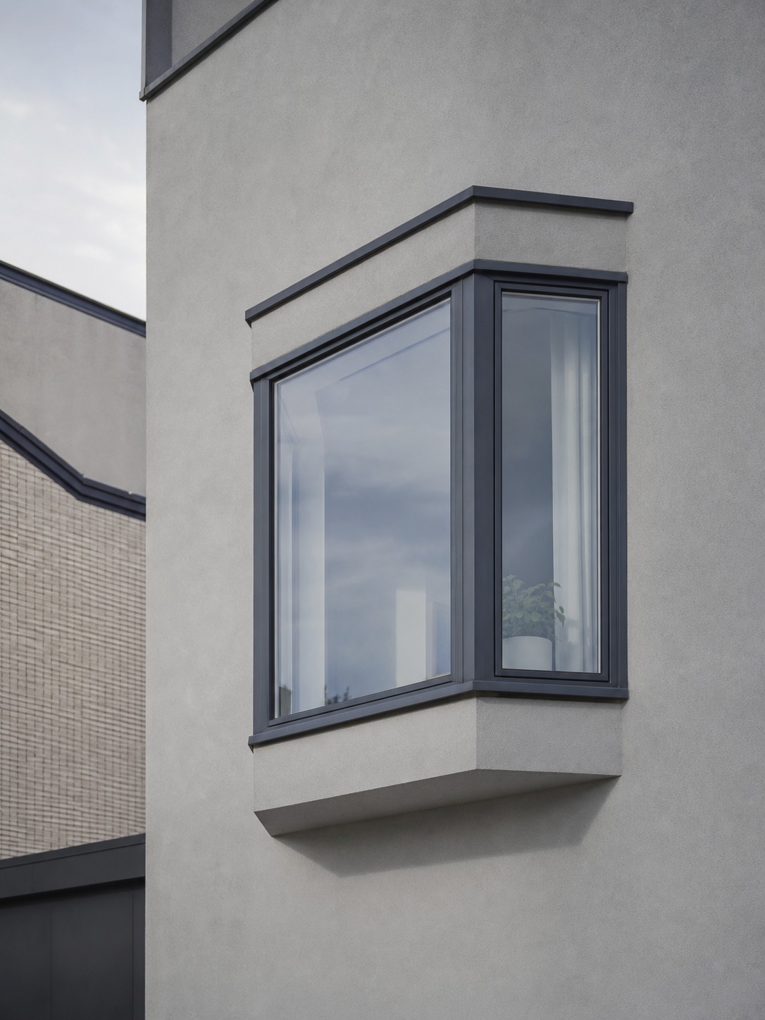 Bay window projecting from a facade and changing the geometry of the flat wall plane.