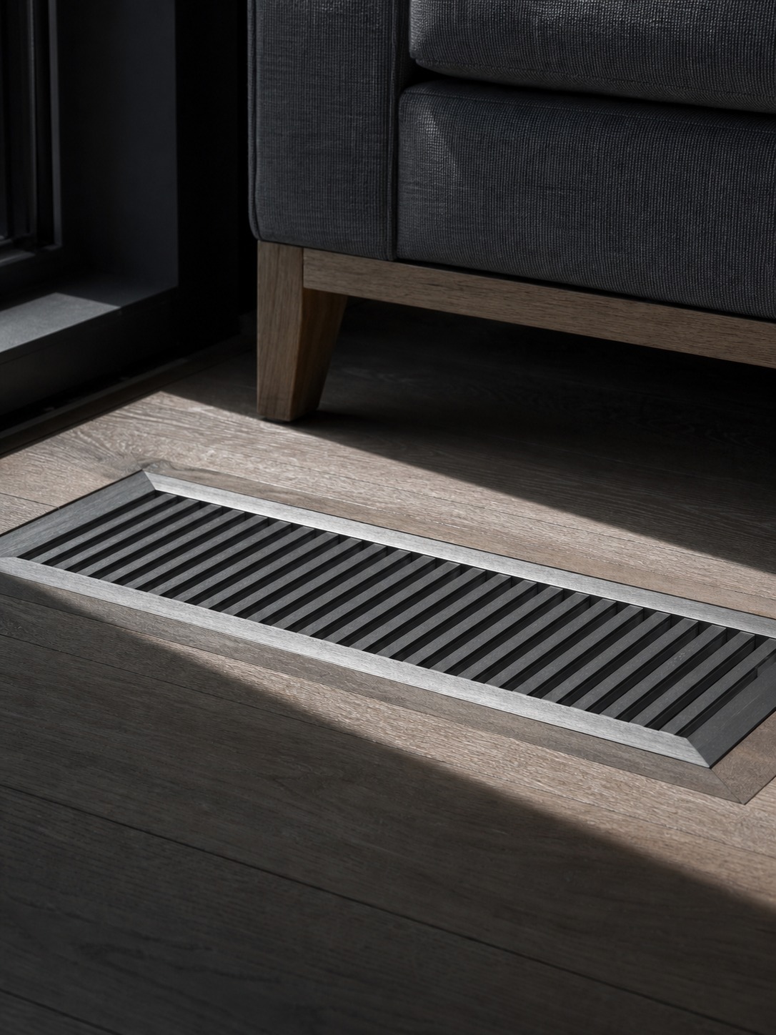 Clear floor register airflow path Unobstructed floor register beside a low sofa showing a clear airflow path across the floor. | Sky Rye Design Unobstructed floor register beside a low sofa showing a clear airflow path across the floor.