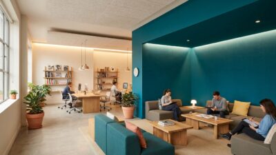 Creative agency office with a single saturated accent wall in a collaborative breakout space