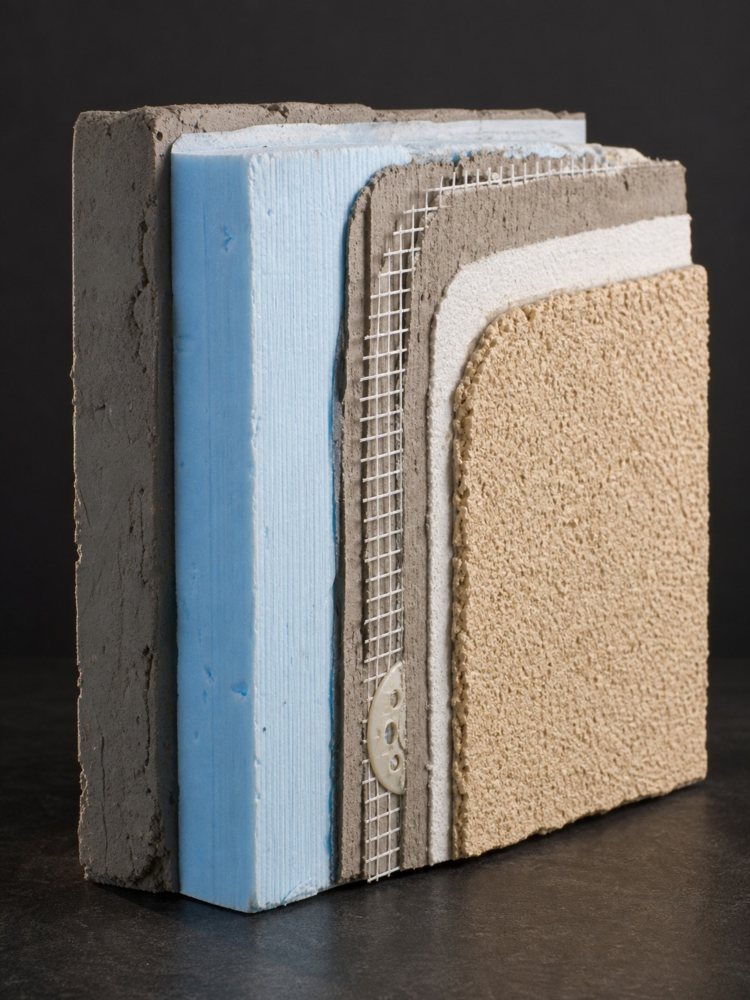 EIFS wall assembly cutaway sample Studio cutaway sample of an EIFS wall assembly showing insulation, mesh, and finish layers. | Sky Rye Design Studio cutaway sample of an EIFS wall assembly showing insulation, mesh, and finish layers.